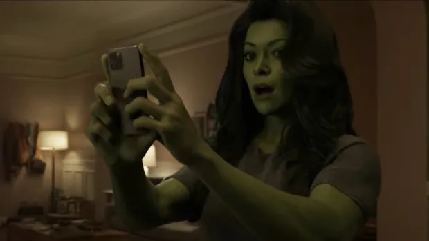 A imagem mostra She-Hulk olhando para um celular